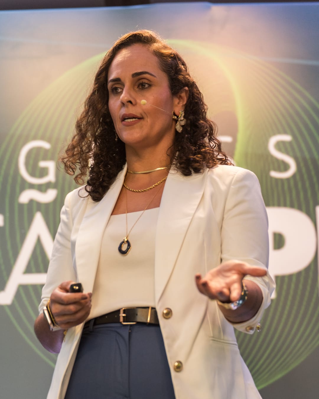 Francine Sinnott palestrando, de blazer branco, com microfone de cabeça.