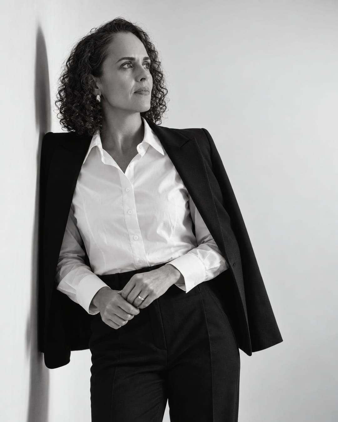 Retrato em preto e branco de Francine Sinnott, de camisa branca e blazer sobre os ombros, olhando para o lado.